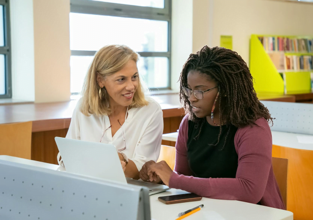 Deux personnes dans une bibliothèque en train de faire un cours particulier.